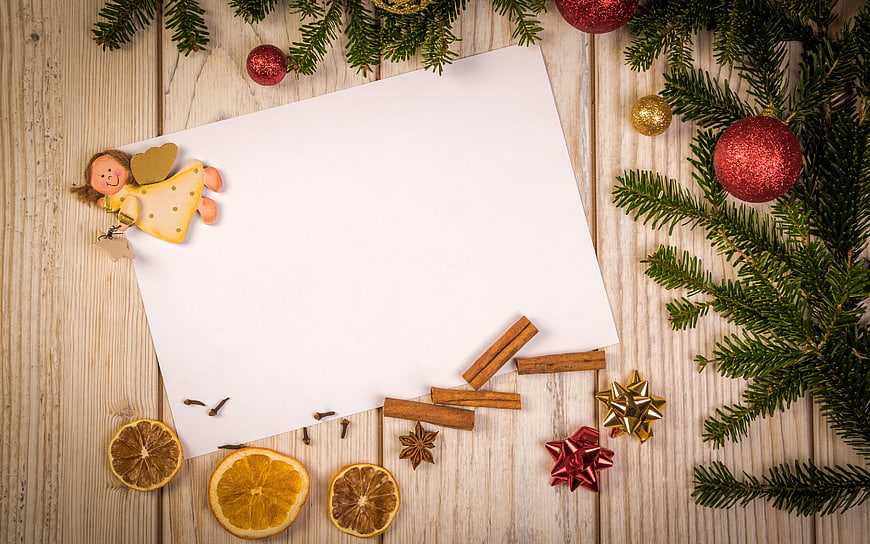 Christmas flat lay with white paper, pine branches, and dried orange slices
