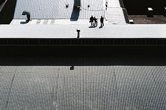 High angle view of three people on industrial metal roof