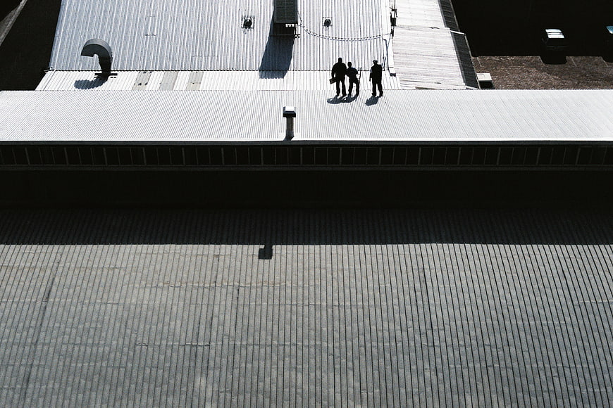 High angle view of three people on industrial metal roof