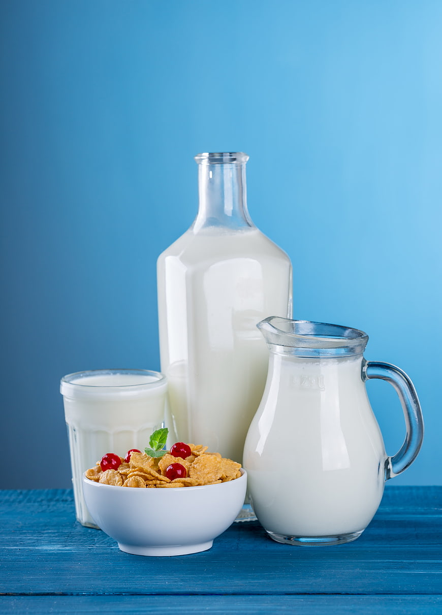Healthy breakfast cereal with milk and cherries on blue background