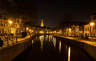 Night view of Amsterdam canal with illuminated church tower