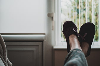Relaxed Woman's Feet in Slippers by Window