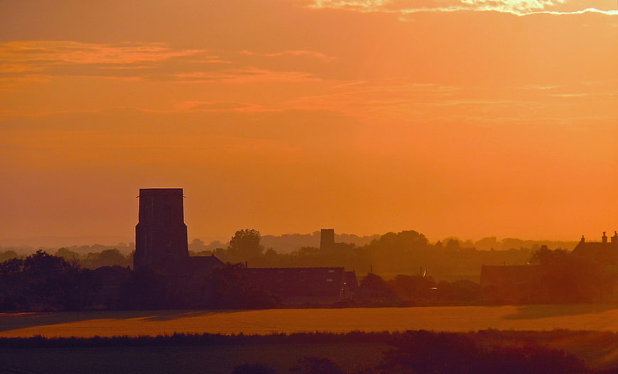 Silhouette of Rural Church Tower at Vibrant Orange Sunset