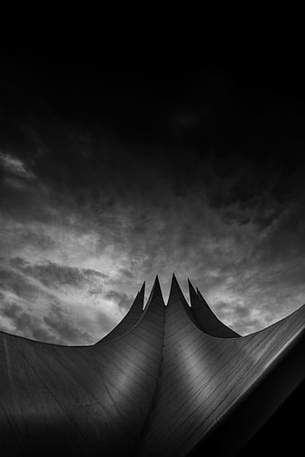 Dramatic Black and White Architectural Roof Against Cloudy Sky