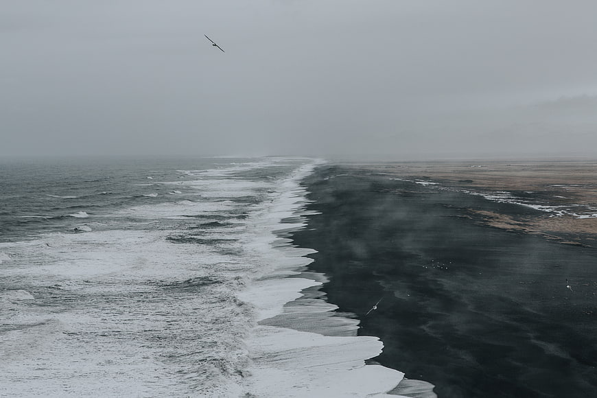 Aerial View of Stormy Ocean Waves Crashing on Black Sand Beach