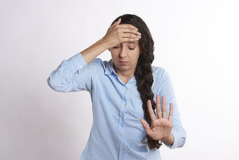Stressed woman holding head and hand in stop gesture