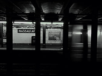 Black and white photo of Nassau Avenue subway station with moving train