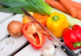 Fresh vegetables and chef knife on rustic white wood