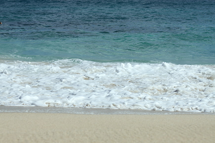 Foamy Ocean Waves Washing Up on Sandy Beach Shore