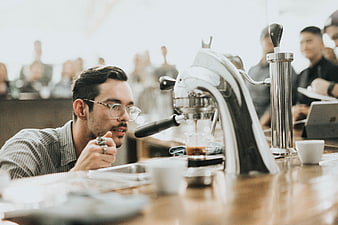 Barista making espresso in a busy coffee shop