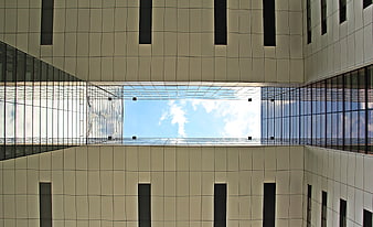 Worm's eye view of modern skyscraper courtyard and sky