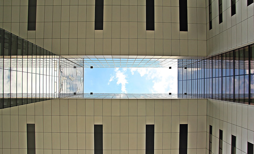 Worm's eye view of modern skyscraper courtyard and sky