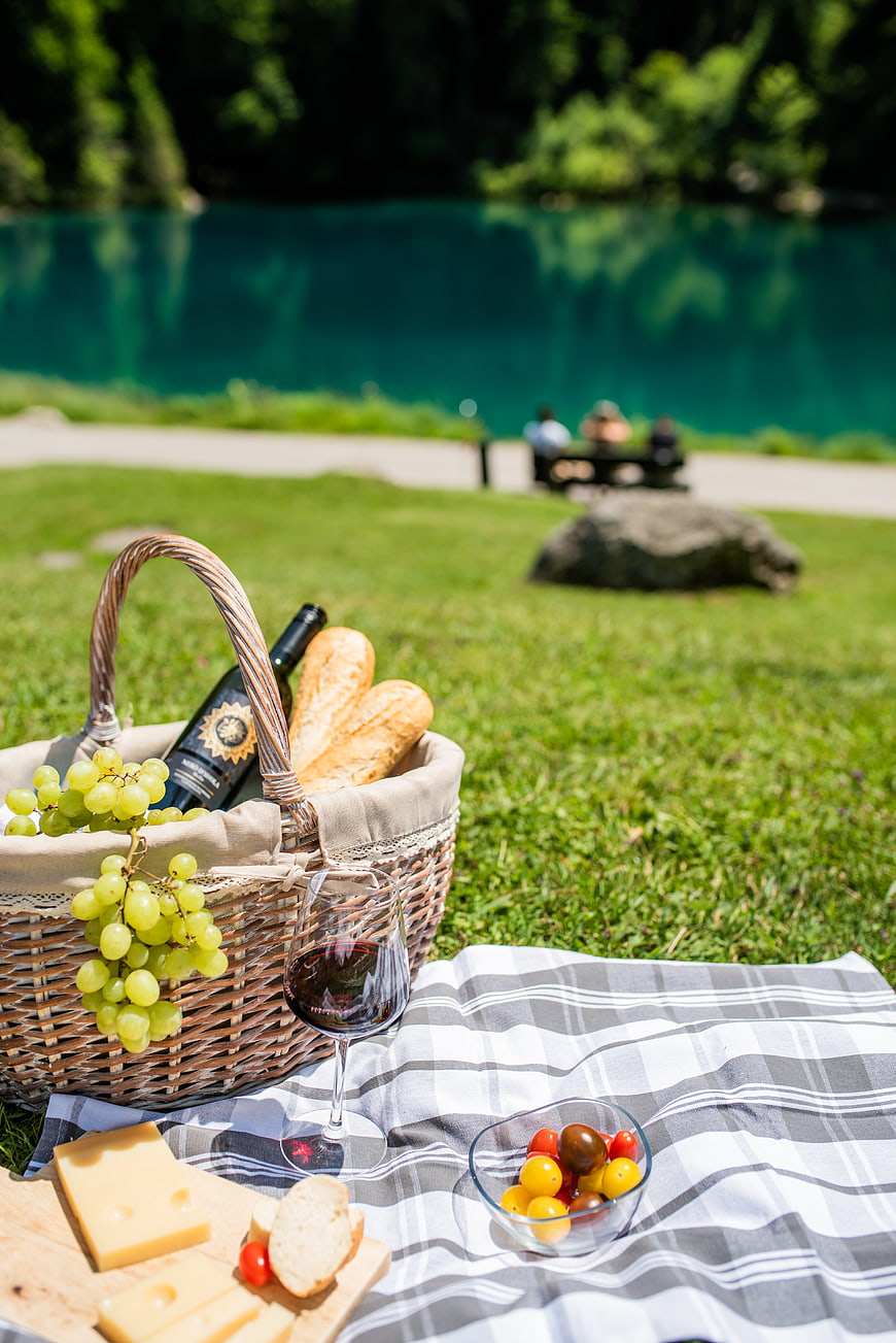 Summer Picnic Basket with Wine, Cheese, and Grapes by Lake