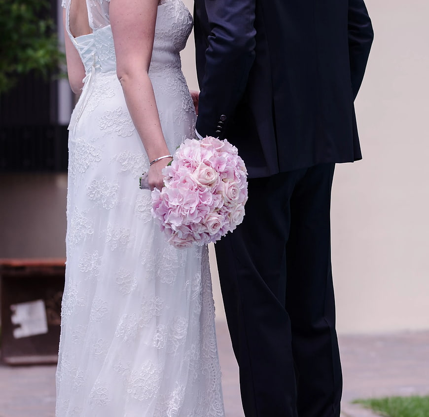 Bride and Groom Holding Pink Rose Bouquet