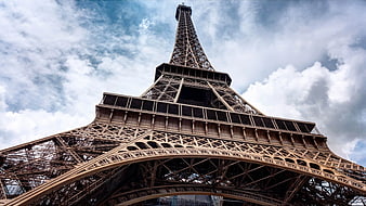 Low Angle View of Eiffel Tower Against Cloudy Sky