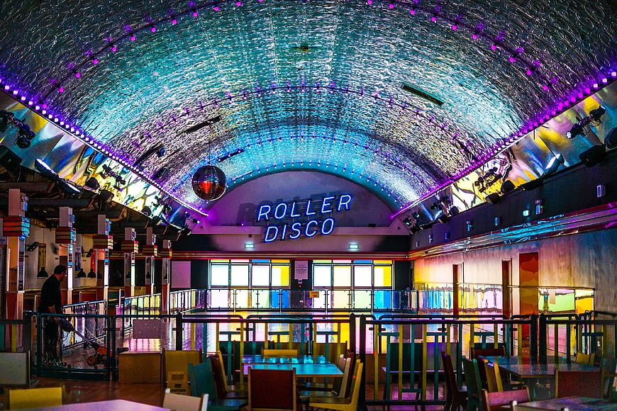 Retro Roller Disco Interior with Neon Sign and Disco Ball