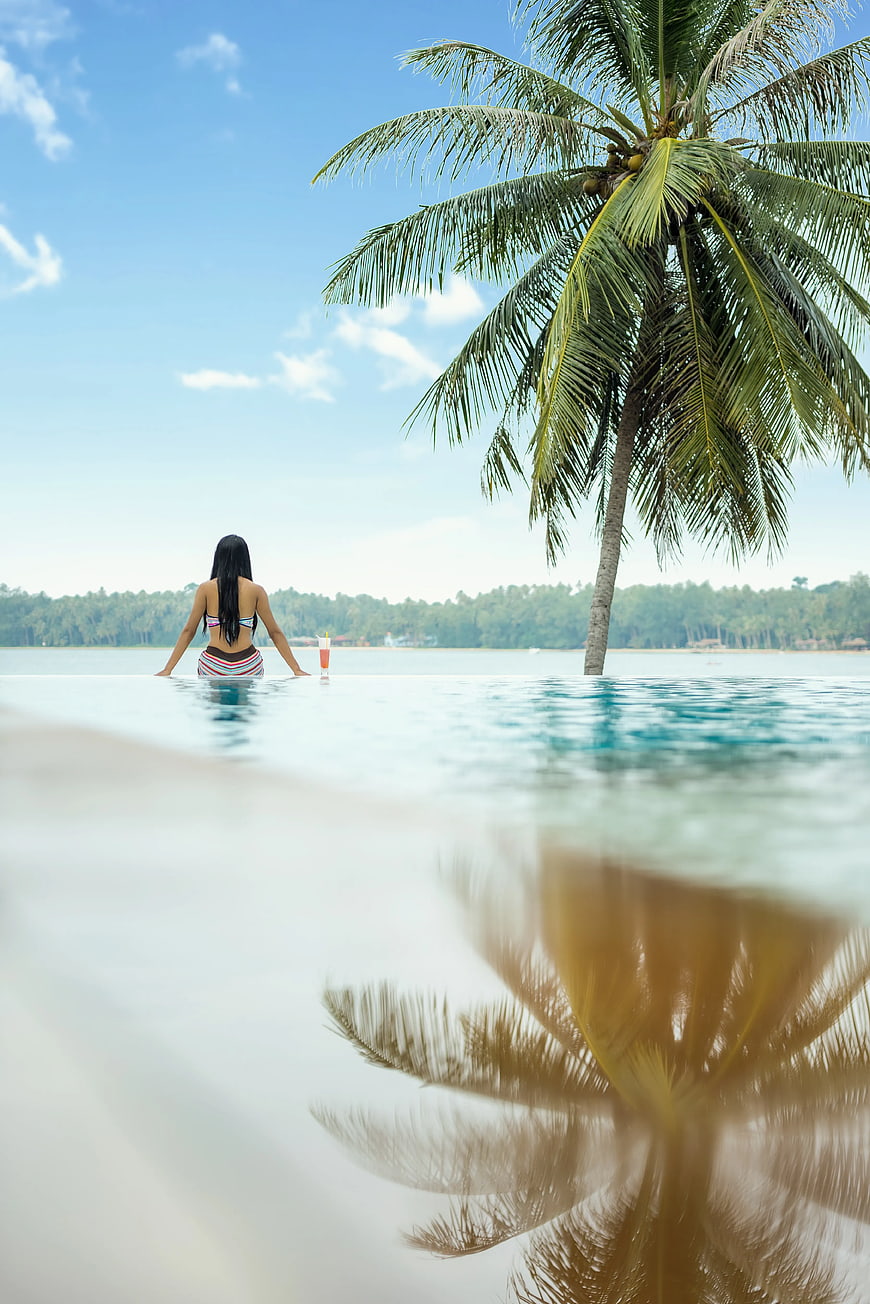 Woman in Infinity Pool with Palm Tree Reflection