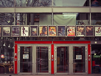 Cinema Entrance with Movie Posters and Red Doors