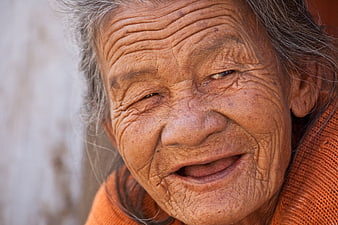 Close-up portrait of smiling elderly woman with wrinkled face
