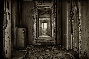Dark abandoned hallway with peeling paint and debris