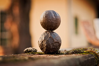 Balanced stones on mossy surface with blurred background