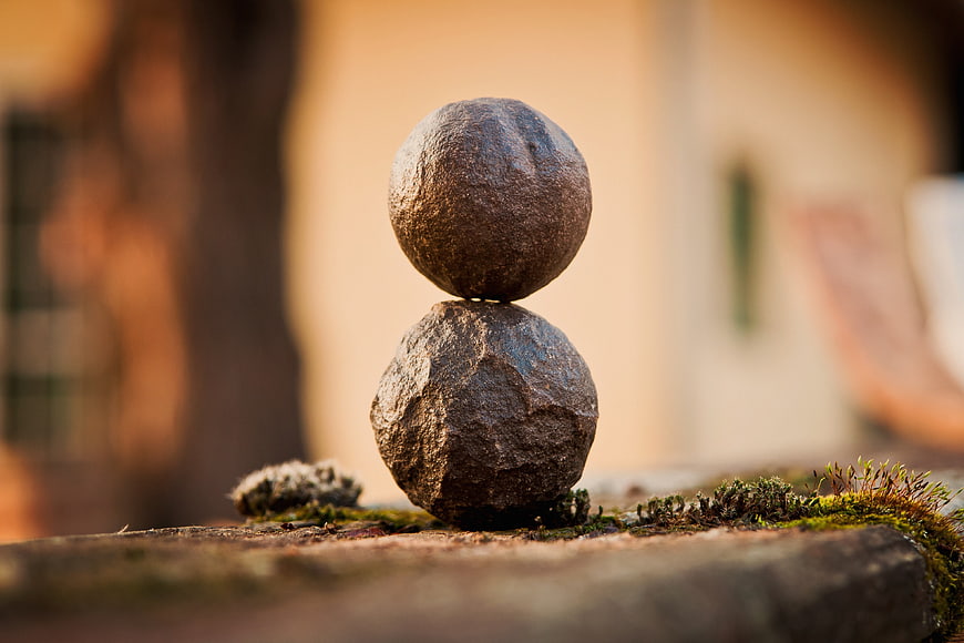 Balanced stones on mossy surface with blurred background