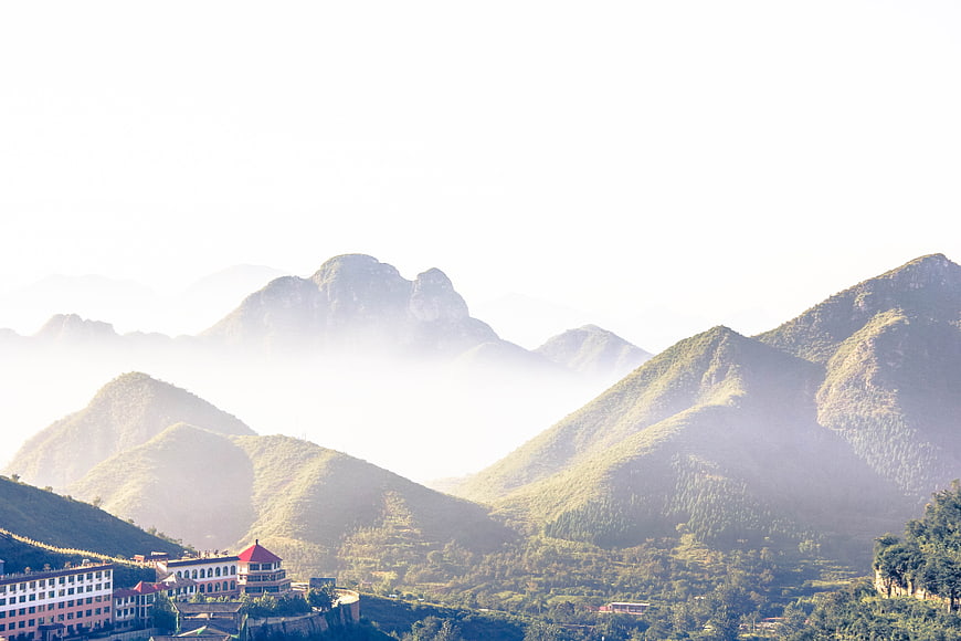 Misty Mountain Landscape with Buildings in Valley