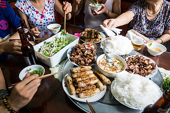 Family Sharing Vietnamese Feast with Spring Rolls and Noodles