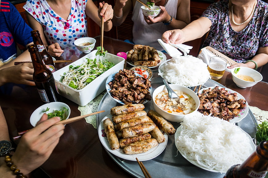 Family Sharing Vietnamese Feast with Spring Rolls and Noodles