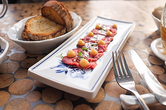 Beef carpaccio with bread on rustic wooden table