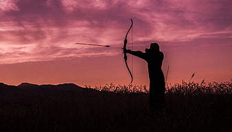 Silhouette of Archer Shooting Bow at Pink Sunset