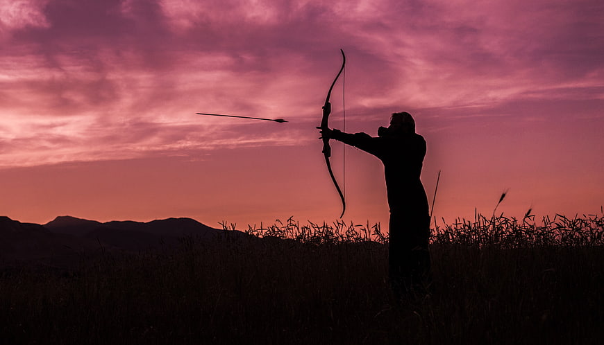 Silhouette of Archer Shooting Bow at Pink Sunset