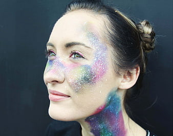Woman with colorful galaxy glitter makeup on face