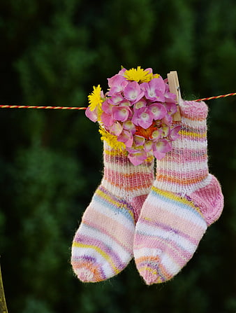 Knitted baby socks with flowers on clothesline