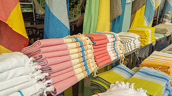 Colorful folded beach towels stacked at a market stall