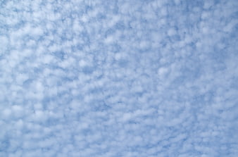 Soft blue sky with fluffy white clouds texture background