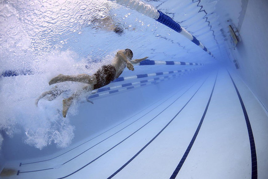 Underwater Action Shot of Male Swimmer in Pool Lane