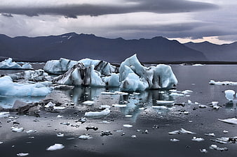 Dramatic Icebergs Floating in Glacial Lagoon with Mountains