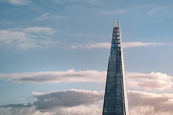 The Shard London skyscraper against blue sky with clouds