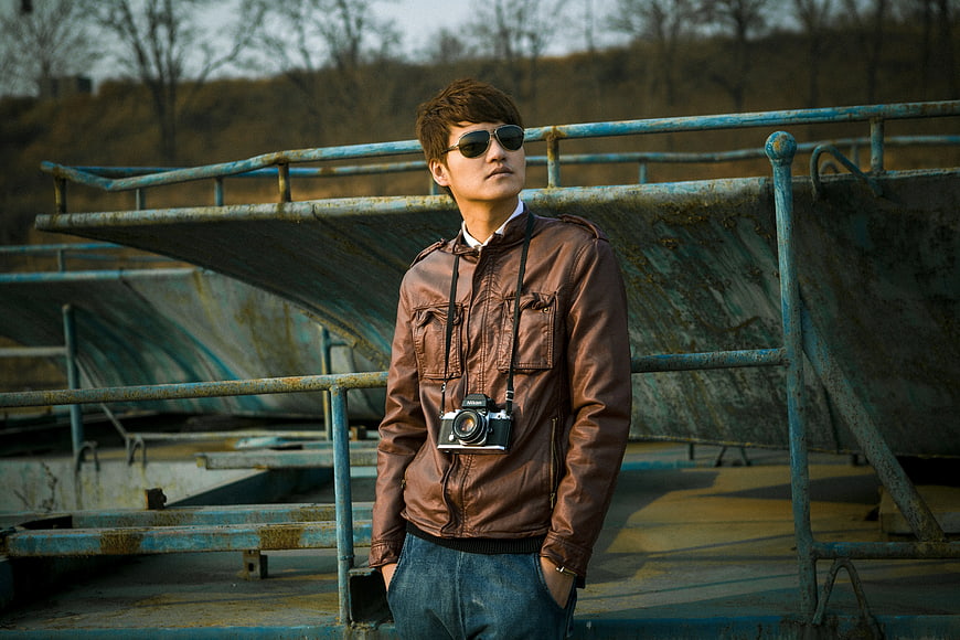 Man in Brown Leather Jacket with Vintage Camera at Skate Park