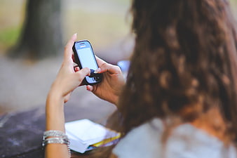 Woman using smartphone outdoors with blurred background