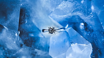 Diamond ring on blue ice crystals luxury background