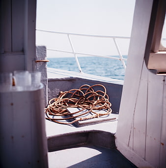 Coiled rope on boat deck with ocean view