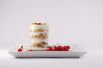 Healthy yogurt parfait with granola and berries on white plate