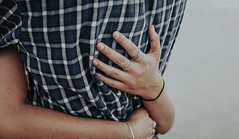 Close-up of hands hugging person in plaid shirt