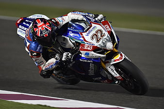 Motorcycle racer leaning into a turn on a race track