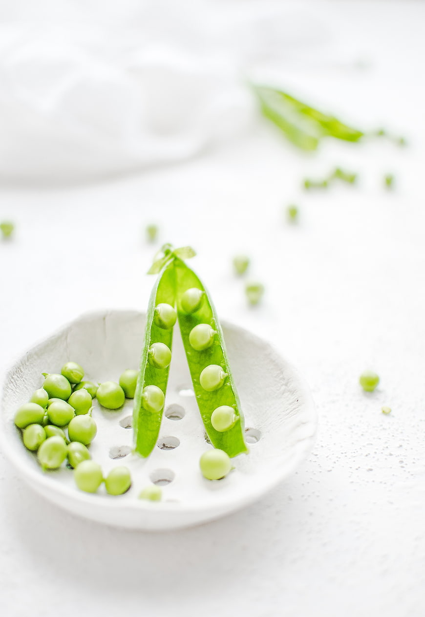 Fresh Green Peas in Pod on White Ceramic Plate