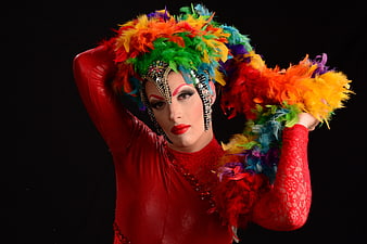 Drag Queen in Red Costume with Colorful Feather Headdress