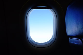 Airplane Window View of Blue Sky During Flight
