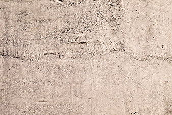 Textured beige concrete wall background with cracks and rough surface